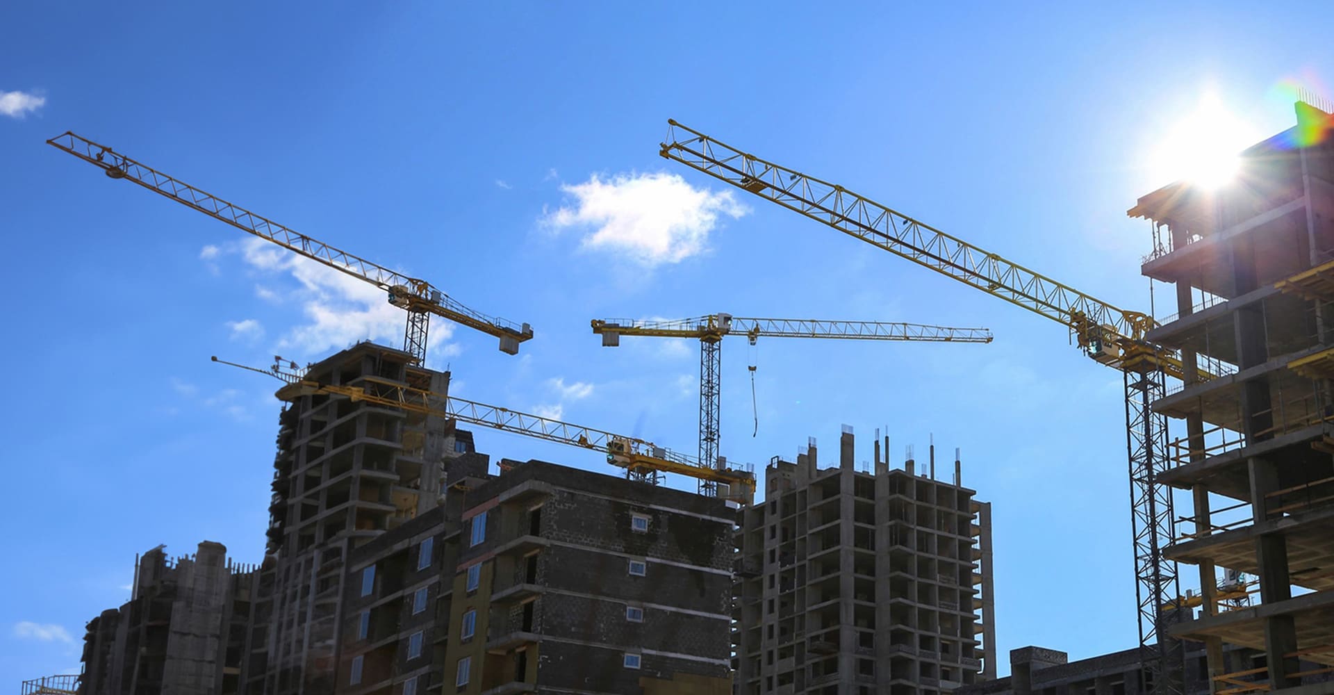 Construction site with cranes against a blue sky.
